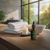 Das Wellrelaxx Haaröl auf einem Handtuchstapel im Badezimmer, für eine natürliche und stärkende Haarpflege-Routine.
